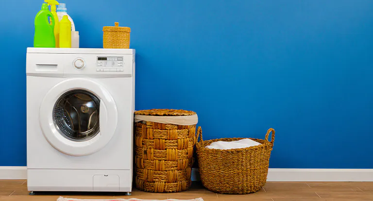 washing-machine-with-laundry-on-blue-wall- washing-machine-with-laundry-on-blue-wall-