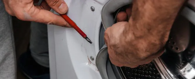 handyman-repairing-a-washing-machine-the-hands-of