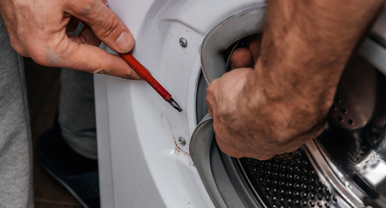 handyman-repairing-a-washing-machine-the-hands-of