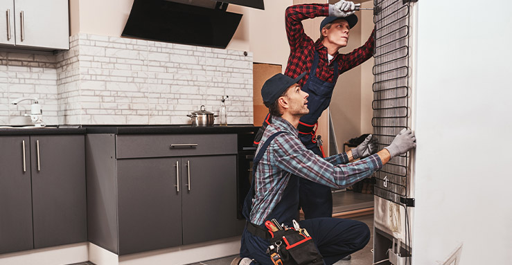 two-handymen-with-refrigerator-young-men-mechanic-